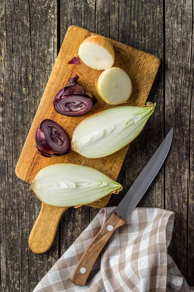 Gehalveerde verse bollen. Gesneden uien en mes. — Stockfoto