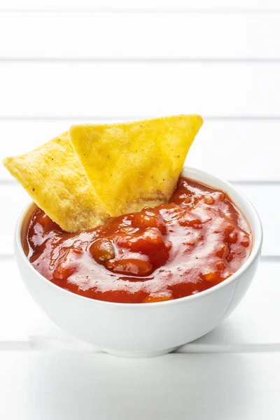 Chipsy nacho kukurydziane i dip pomidorowy. — Zdjęcie stockowe