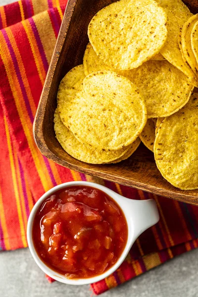 Chips de nacho de milho redondo e molho de tomate. Batatas de tortilla amarelas e — Fotografia de Stock