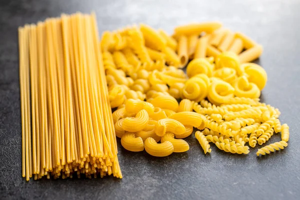 Varios Tipos Pasta Italiana Cruda Sobre Mesa Negra — Foto de Stock