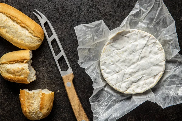 ブリー チーズ キッチンテーブルの上にバゲットが付いている白い柔らかいチーズ トップ表示 — ストック写真
