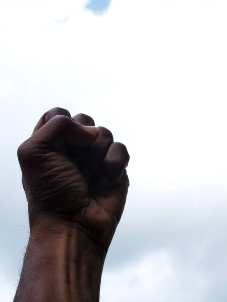 非洲裔美国人紧握拳头的照片 以天空为背景 象征着权力和黑人的骄傲 — 图库照片