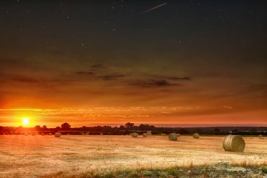 Saman balya yıldız gece göstermek için takas gökyüzü ile gün batımında. Norfolk kırsal kırpma alanları üzerinde turuncu güzel panoramik akşam güneşi