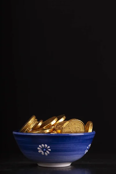 Pot met gouden munten op zwarte achtergrond — Stockfoto