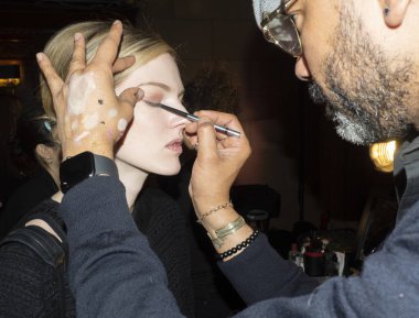 New York, NY, USA - February 11, 2019: A model prepares backstage for Dennis Basso Fall/Winter 2019 Collection during New York Fashion Week at Cipriani 42nd Street, Manhattan clipart