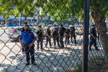 Brooklyn NY ABD - 1 Ağustos 2020: Tpolis memurları, 89 yaşındaki Asyalı bir kadının Bensonhurst 'ta işlenen bir nefret suçunun kurbanı olmasından sonra ırkçılığa ve nefret suçuna karşı dayanışma mitingini izledi.