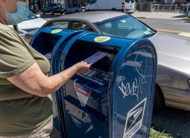 Brooklyn, NY, ABD - 18 Ağustos 2020: Kimliği belirsiz kişi posta krizi, COVID-19 ve yaklaşan seçimler üzerine Birleşik Siates Posta Kutusuna bir mektup bıraktı. 