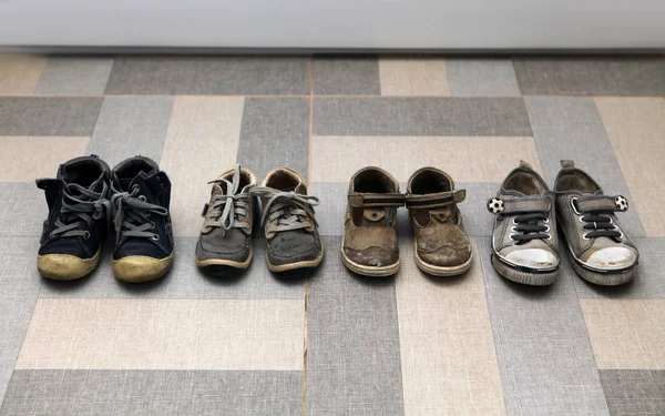 Μικρά Βρώμικα Παπούτσια Και Μπότες Στο Πάτωμα — Φωτογραφία Αρχείου