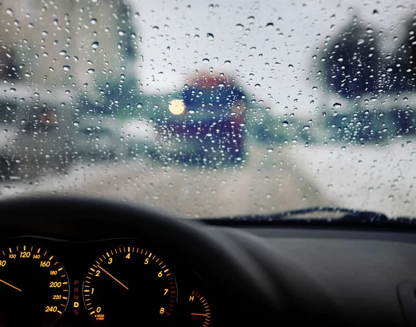 汽车挡风玻璃上的仪表板和雨水滴 — 图库照片