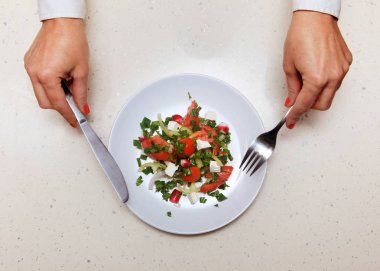 salata beyaz plaka, elinde bıçak ve çatal tutan ziyaretçi