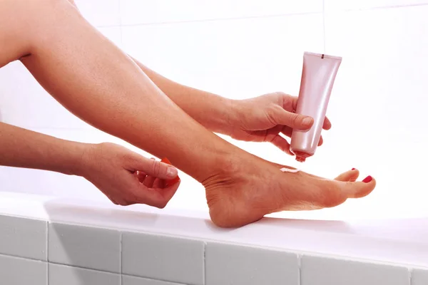 Donna che applica la crema a piedi — Foto Stock