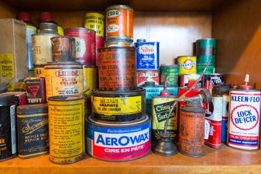 Quebec Province, Canada - 25th January 2015: A stack of old product tins for sale in a flea market, including motor products, paints, household repairs and cleaning agents clipart