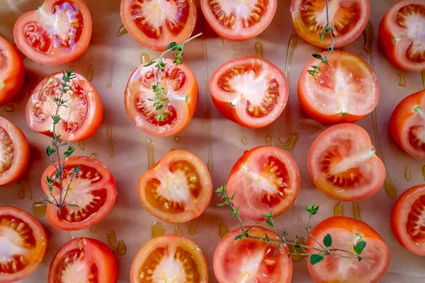 准备西红柿晒干或烘焙 用新鲜百里香和橄榄油在烤羊皮纸上切西红柿 顶部视图水平格式 — 图库照片