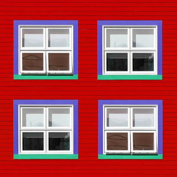 红色木墙上的紫色 绿色和白色窗户 加拿大马格达伦岛的房子的极简主义风格 在明亮的色彩与文本的空间 — 图库照片