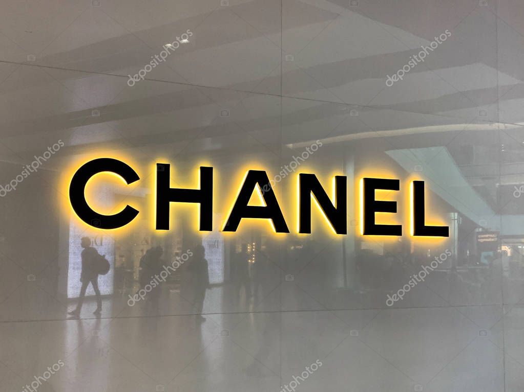 London, UK - 20th May 2019: Chanel store in Heathrow airport shopping mall. Duty Free shop with passengers reflected in the facade. Iconic sign of this French Design House.