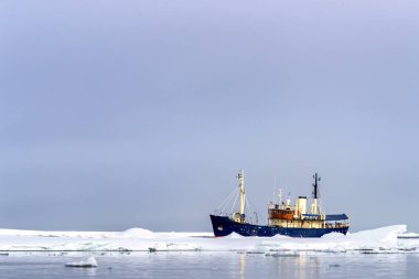 Icebreaker moves the the pack ice off the coast of Svalbard, a Norwegian archipelago between mainland Norway and the North Pole.  clipart