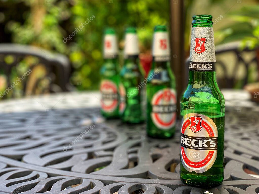 Southampton, UK - 2nd June 2020: Becks beer bottles on a garden table during an early summer hot spell of sunny weather.