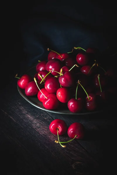 Σκούρα Κόκκινα Κεράσια Ένα Πιάτο Κασσίτερου Χαμηλό Φως Όρθια Σύνθεση — Φωτογραφία Αρχείου