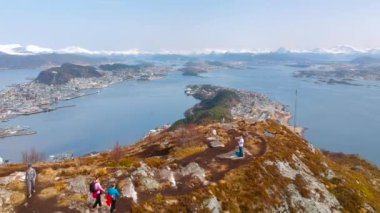 Alesund, Norveç - 14 Nisan 2018: Norveç Fiyordu manzaralı Sukkertoppen Tepesi'ndeki yürüyüş insanlar. Sugar Loaf ilk 314 metre yüksekliğinde hill adlı Norveç'in sahil şeridi üzerinde Alesund şehir içinde