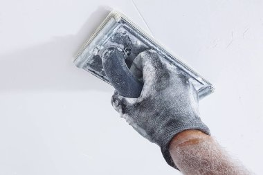Hand of plasterer polishing ceiling clipart