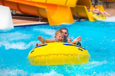 Baba ve küçük oğlu eğleniyor kaydırağı üzerinde güneş tatil sırasında