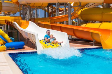 Baba ve küçük oğlu eğleniyor kaydırağı üzerinde güneş tatil sırasında