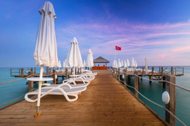 Gün batımında, yan Türk Rivierası'nda ahşap iskele ile güzel sahne