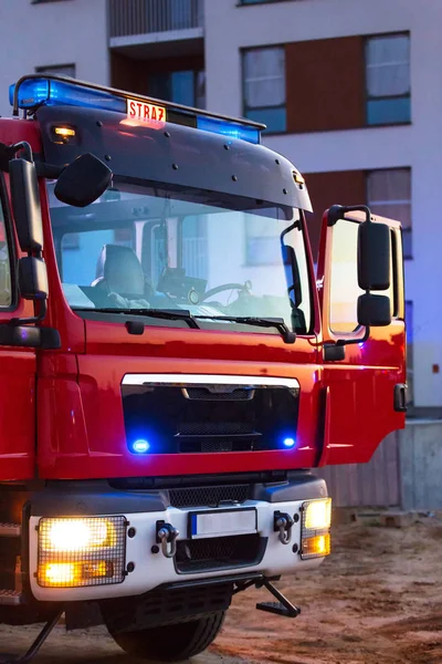 Flashing lights of red fire truck in Poland (Straz) at dusk