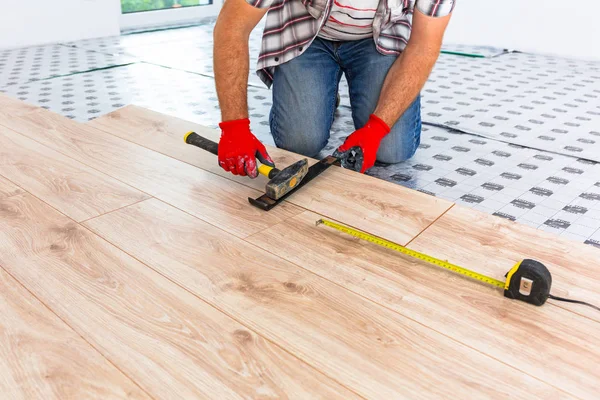 新しい積層木製の床を設置するハンディマン — ストック写真