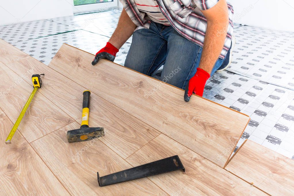 Handyman installing new laminated wooden floor