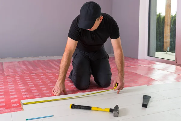 新しい積層木製の床を設置するハンディマン — ストック写真