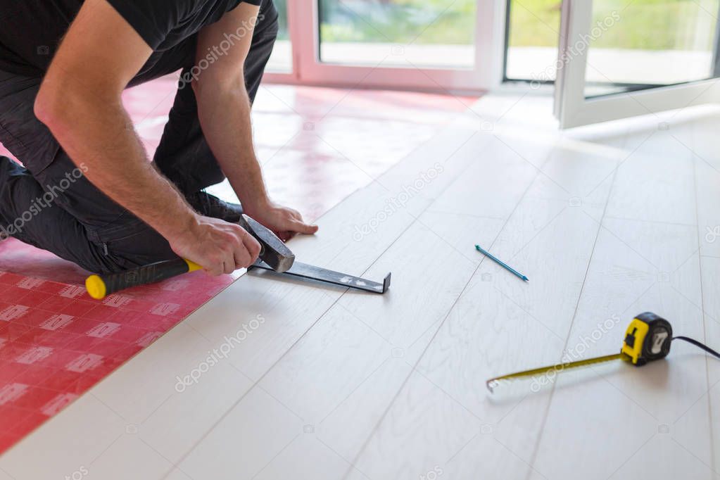 Handyman installing new laminated wooden floor