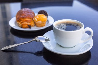 Kahve ve kruvasan deniz kenarındaki masada