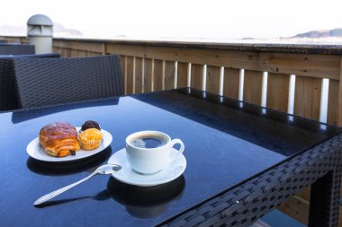 Kahve ve kruvasan deniz kenarındaki masada