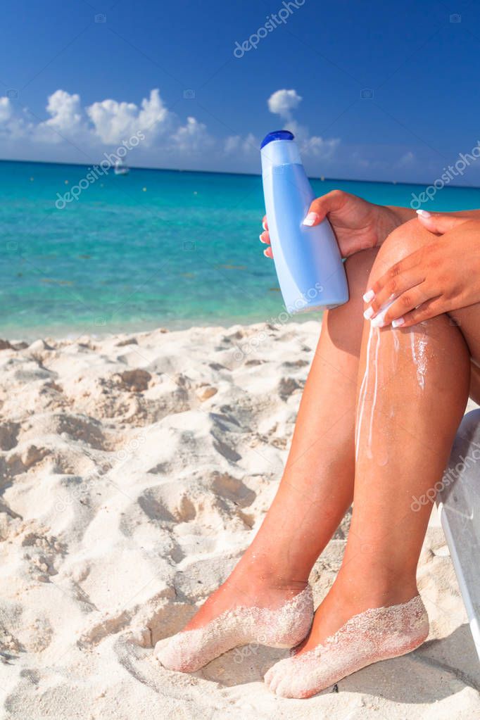 Woman applying sun blocker on the beach