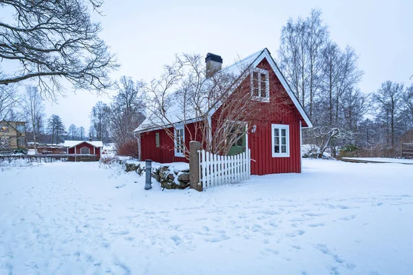 夜明けにスウェーデンで赤の木造住宅と冬景色 ストック写真