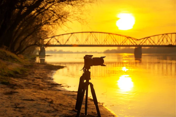 バックグラウンドで素晴らしい夕日と三脚上のカメラのシルエット — ストック写真