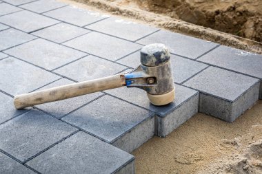 Concrete paver blocks laid with rubber hammer clipart