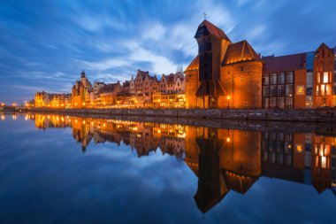 Gdansk, Polonya - 5 Nisan 2018: Gdansk'taki tarihi liman vinci, Polonya'nın alacakaranlıkta Motlawa nehrine yansıdı
