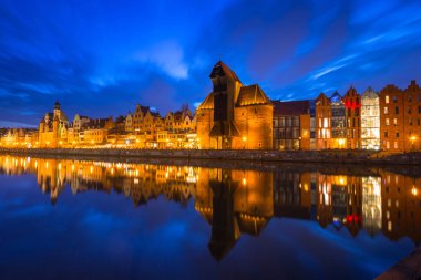 Gdansk, Polonya - 5 Nisan 2018: Gdansk'taki tarihi liman vinci, Polonya'nın alacakaranlıkta Motlawa nehrine yansıdı