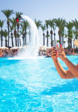 Yaz tatillerinde cep telefonu ile fotoğraf çeken kadın elleri