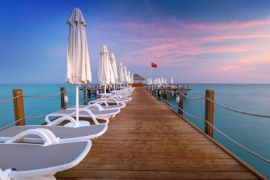 Gün batımında, yan Türk Rivierası'nda ahşap iskele ile güzel sahne