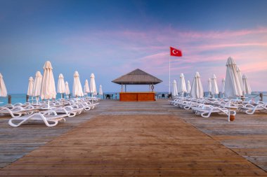 Gün batımında, yan Türk Rivierası'nda ahşap iskele ile güzel sahne