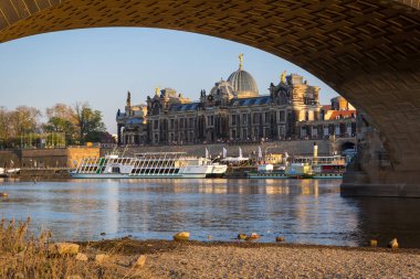 Dresden, Almanya - 19 Nisan 2019: Gün batımında Elbe Nehri'nde Dresden şehir manzarası ve Augustus Köprüsü, Saksonya. Almanya