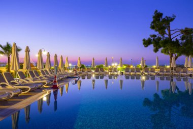 Tekirova, Türkiye - 2 Eylül 2019: Sabah vakti Tekirova'daki Phaselis Rose otelinin güzel havuzu. Tekirova, Türkiye'nin Akdeniz kıyısında yer alan bir sahil beldesi dir.