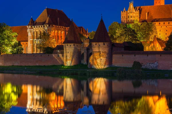 Castillo de Malbork sobre el río Nogat por la noche, Polonia — Foto de Stock