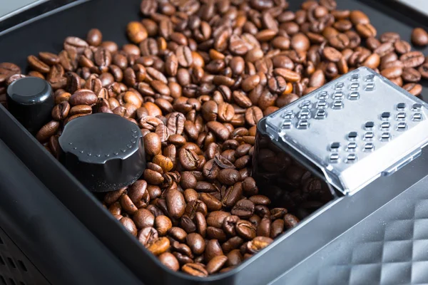Kávová zrna v automatickém mlýnku na kávu — Stock fotografie
