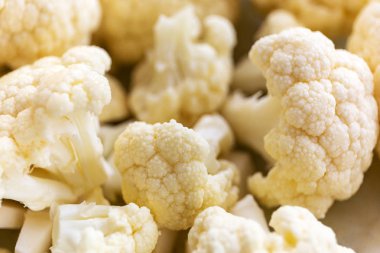 Kesme tahtasındaki küçük karnabahar parçaları.