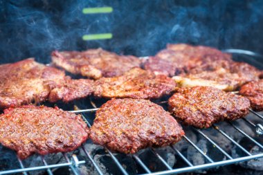 Bahçe barbeküsünde ızgara hamburger.