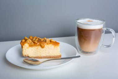 Bir parça peynirli kek, karamel ve fıstık ezmeli latte kahve.